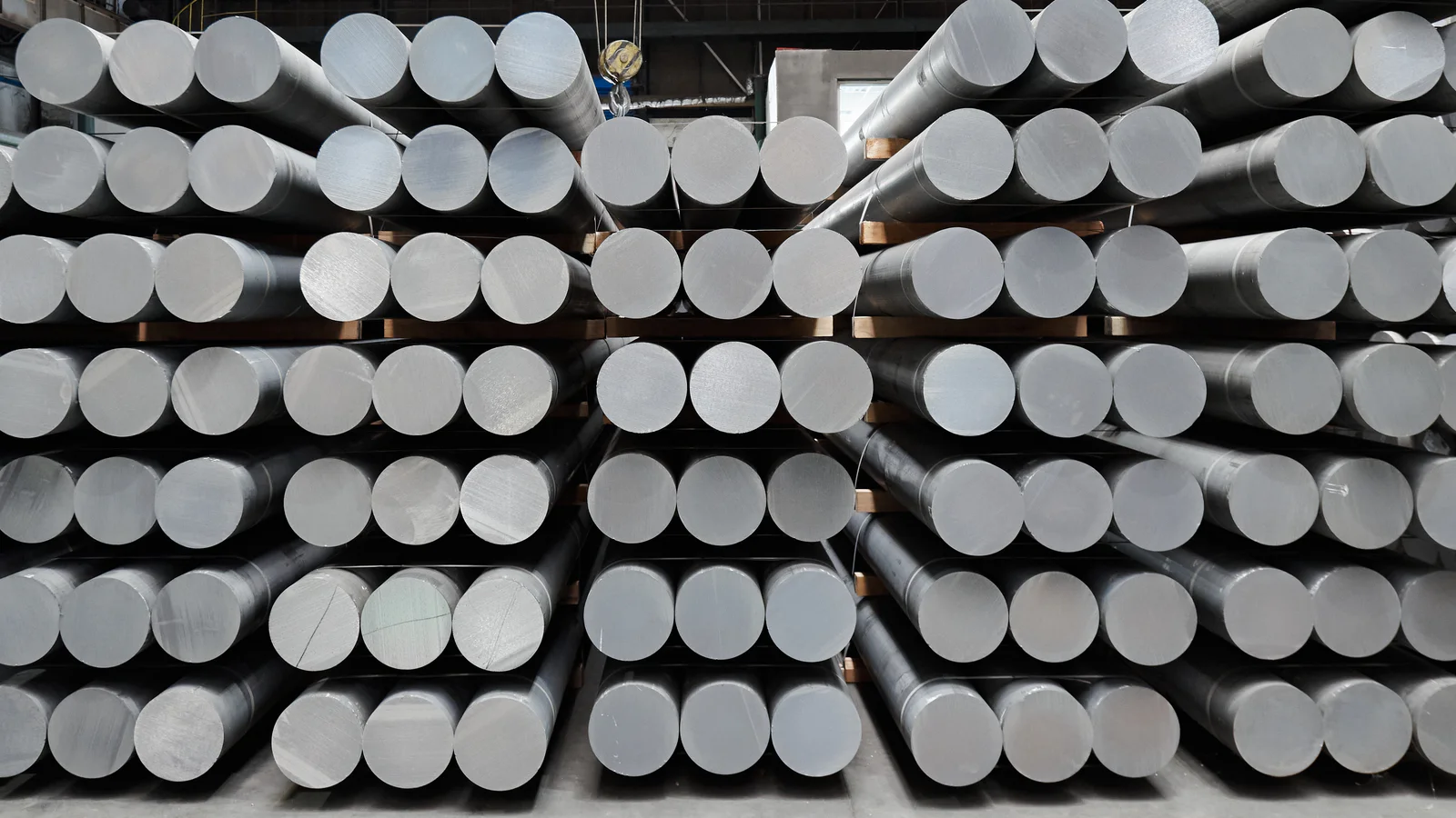 Large-diameter machined round steel bars stacked on heavy warehouse racks